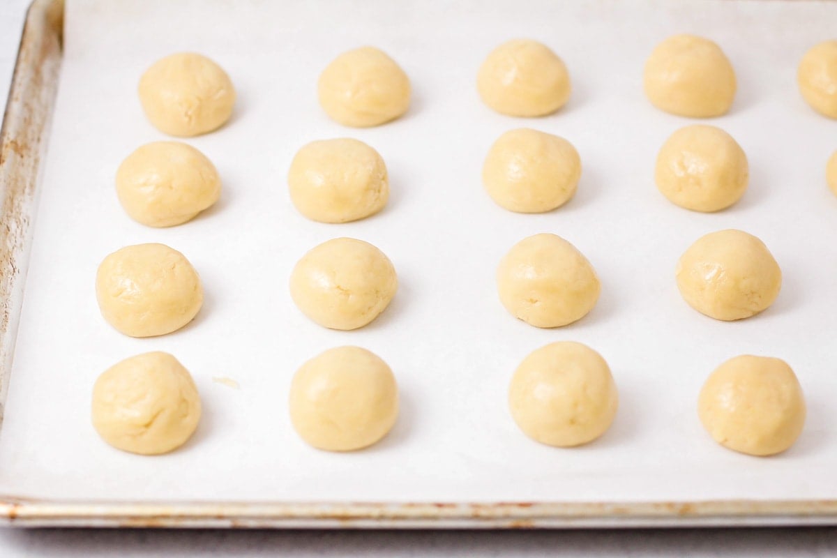 Italian cookie balls on a sheet pan ready for baking.