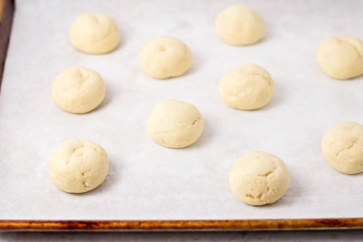 Close up of Italian cookie balls on a sheet pan ready to be baked.