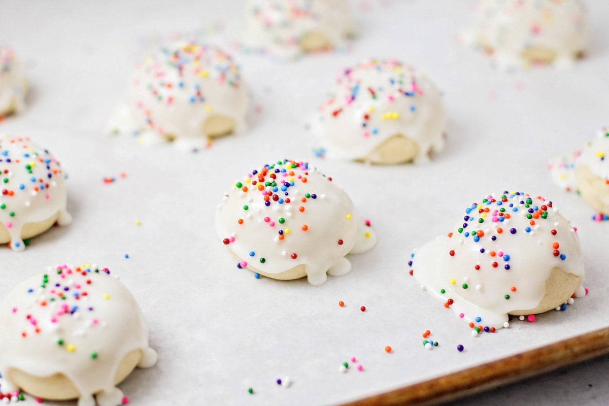 Topping Italian cookies with glaze and sprinkles.
