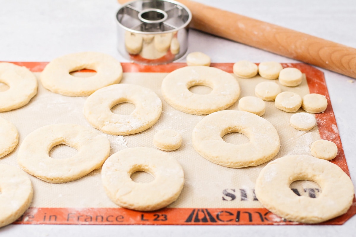 Donuts cut out of dough on Silpat.