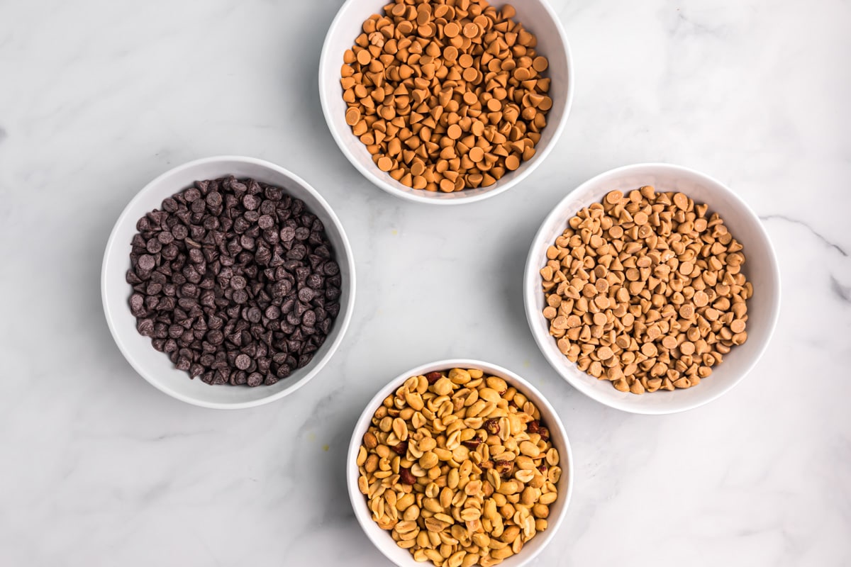 Ingredients for making peanut clusters served in white bowls.