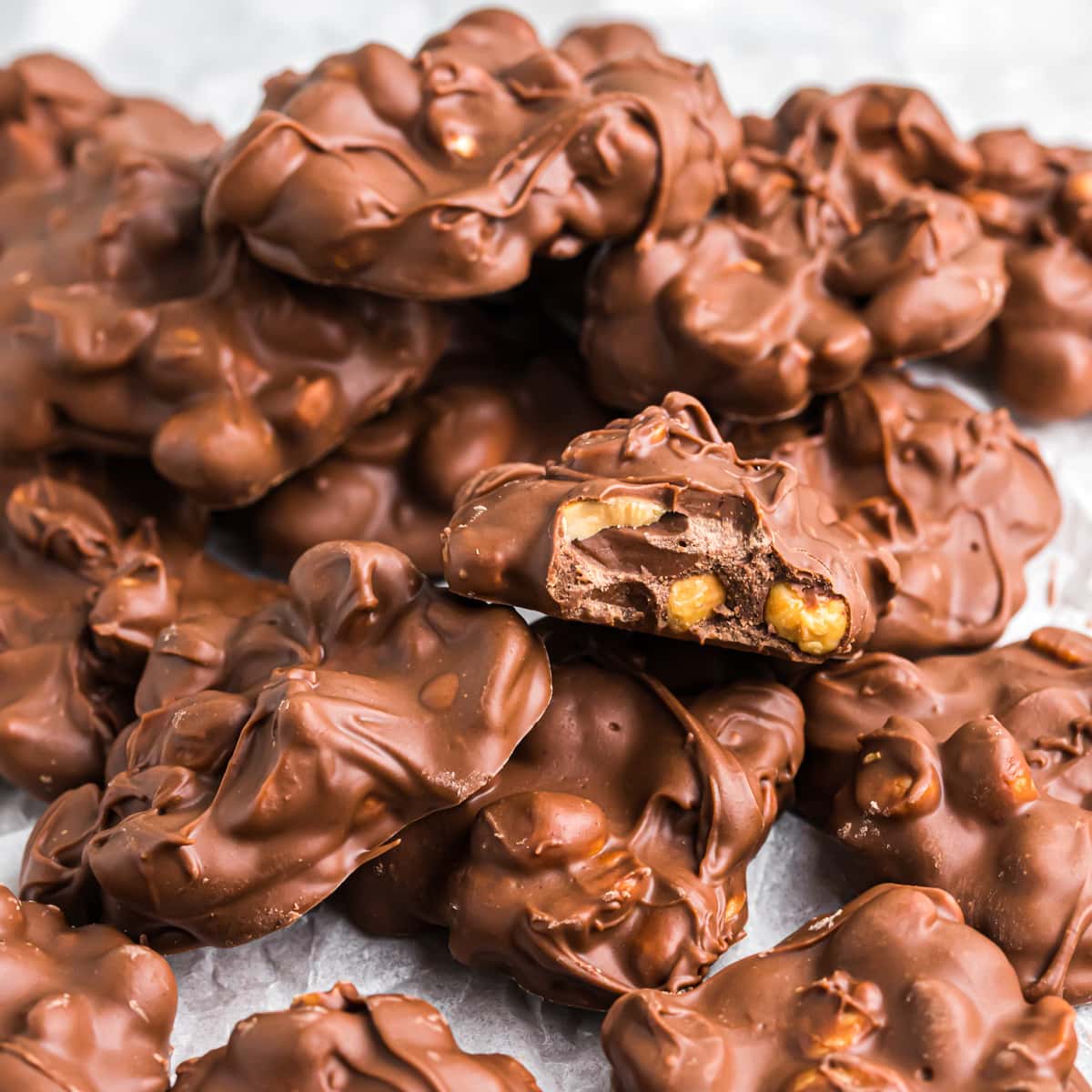 Peanut Clusters piled on wax paper.