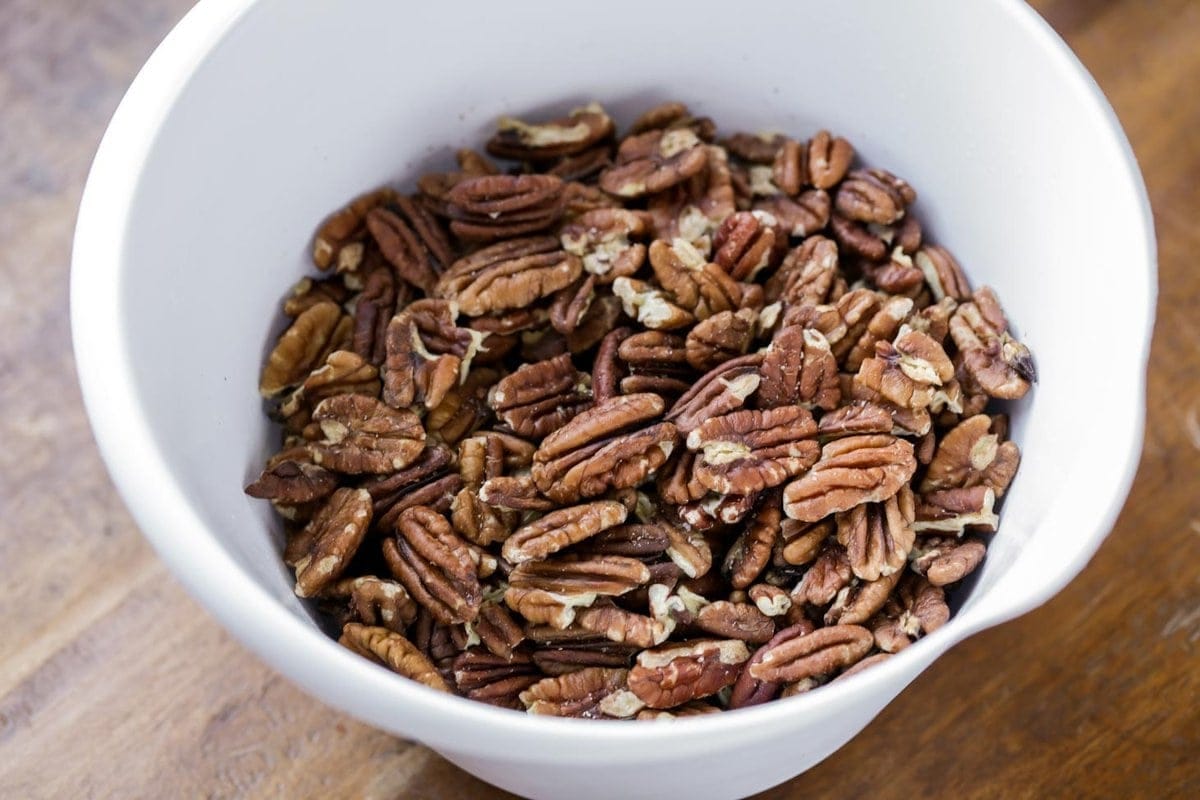 A white bowl of pecan halves.