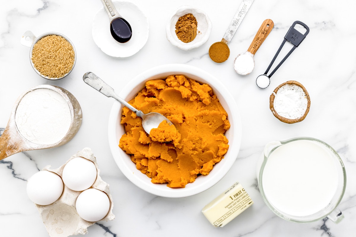 Ingredients for pumpkin waffles set out on a kitchen counter.