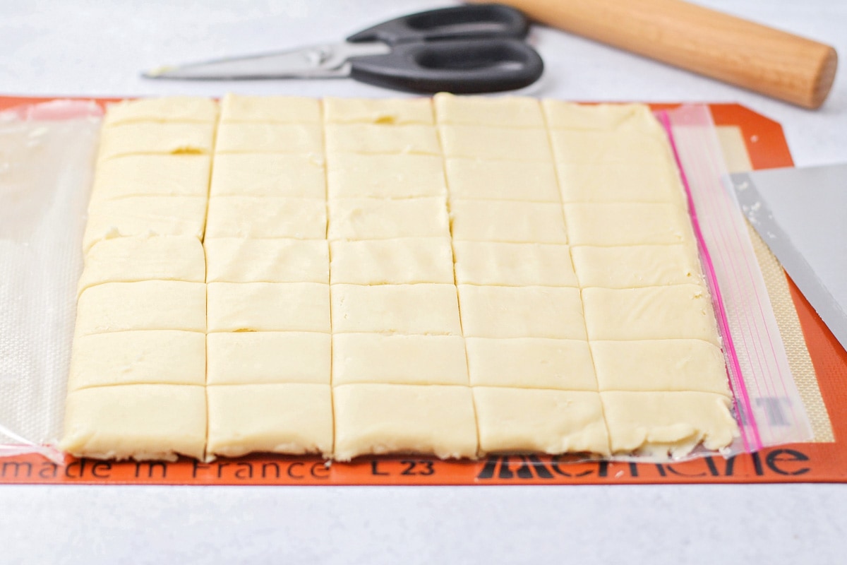 Cutting easy shortbread cookies into squares for baking.