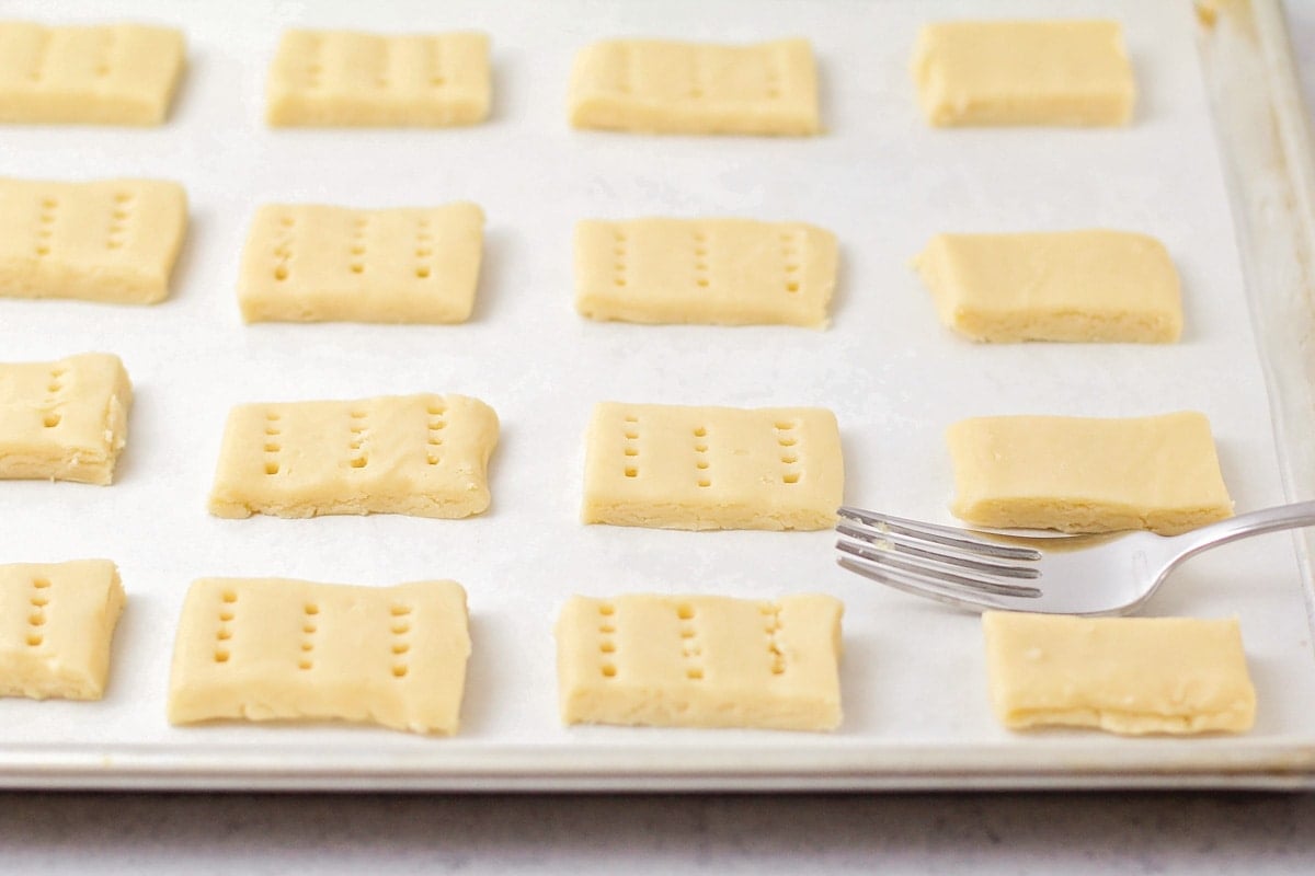 Poking easy shortbread cookies with a fork before baking.