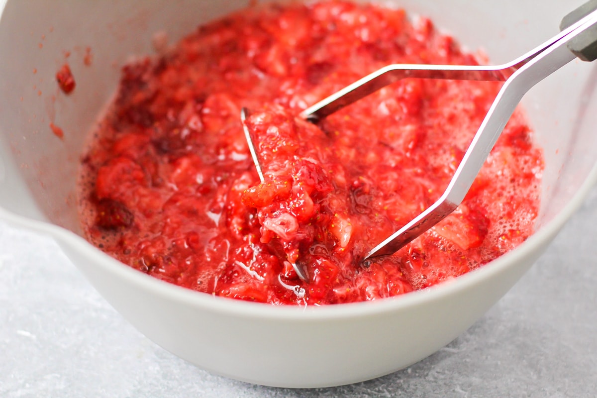 Mashing strawberries for strawberry jam.