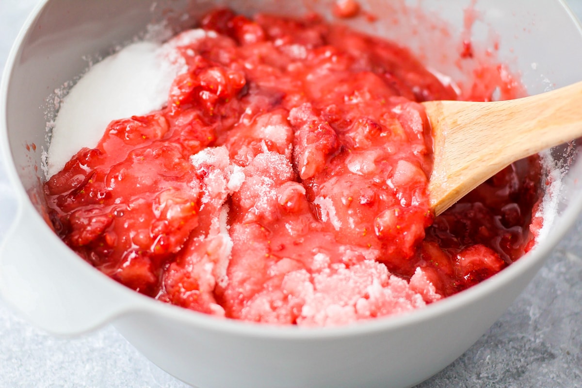 Adding pectin to strawberries for strawberry jam.
