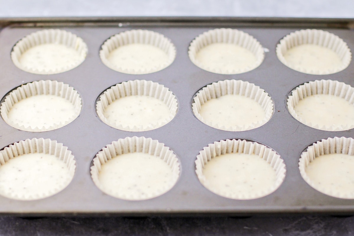 Almond poppy seed muffins batter in cupcake liners ready to be baked.