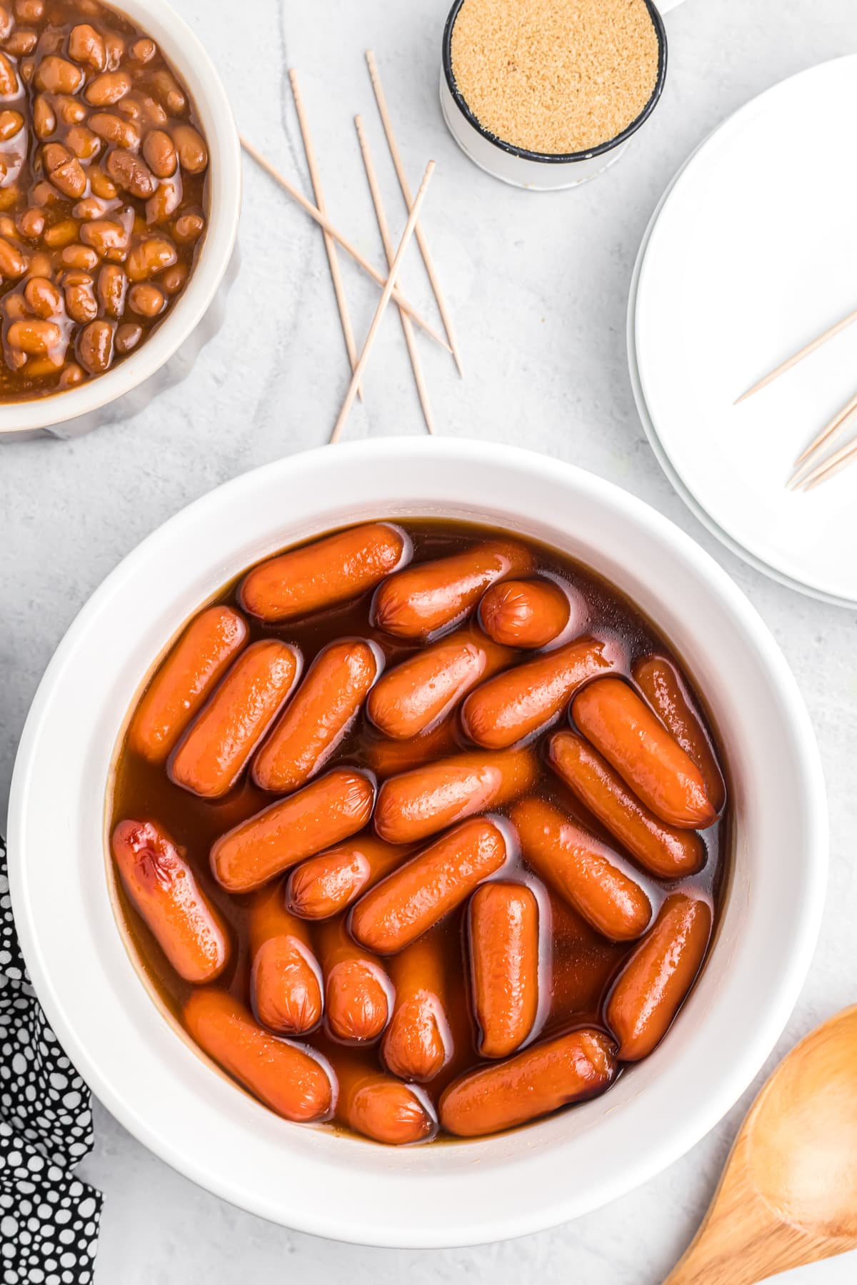Beanie weenies served with beans and toothpicks.