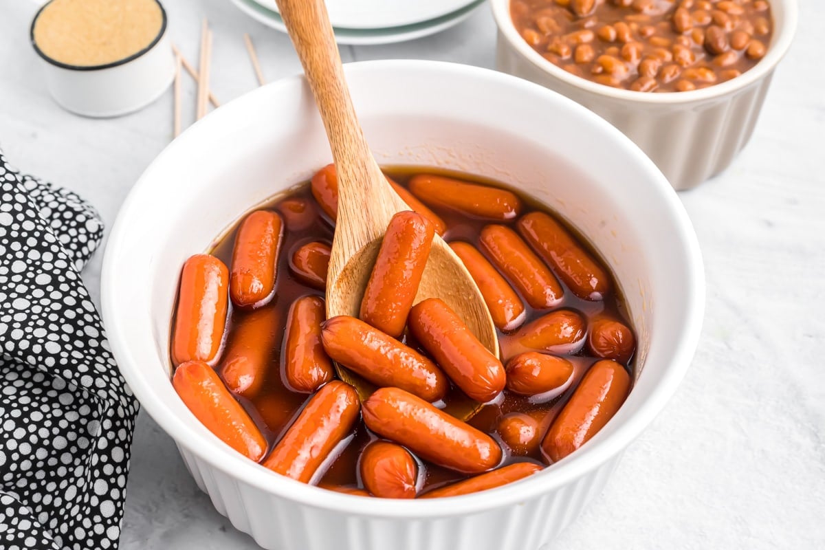 A white bowl filled with brown sugar beanie weenies.