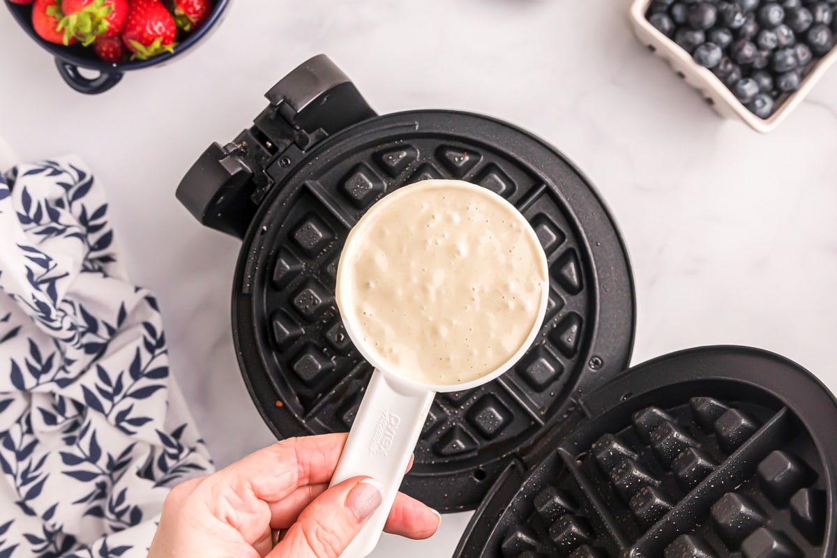 Prepping to pour Bisquick waffle recipe in a waffle iron