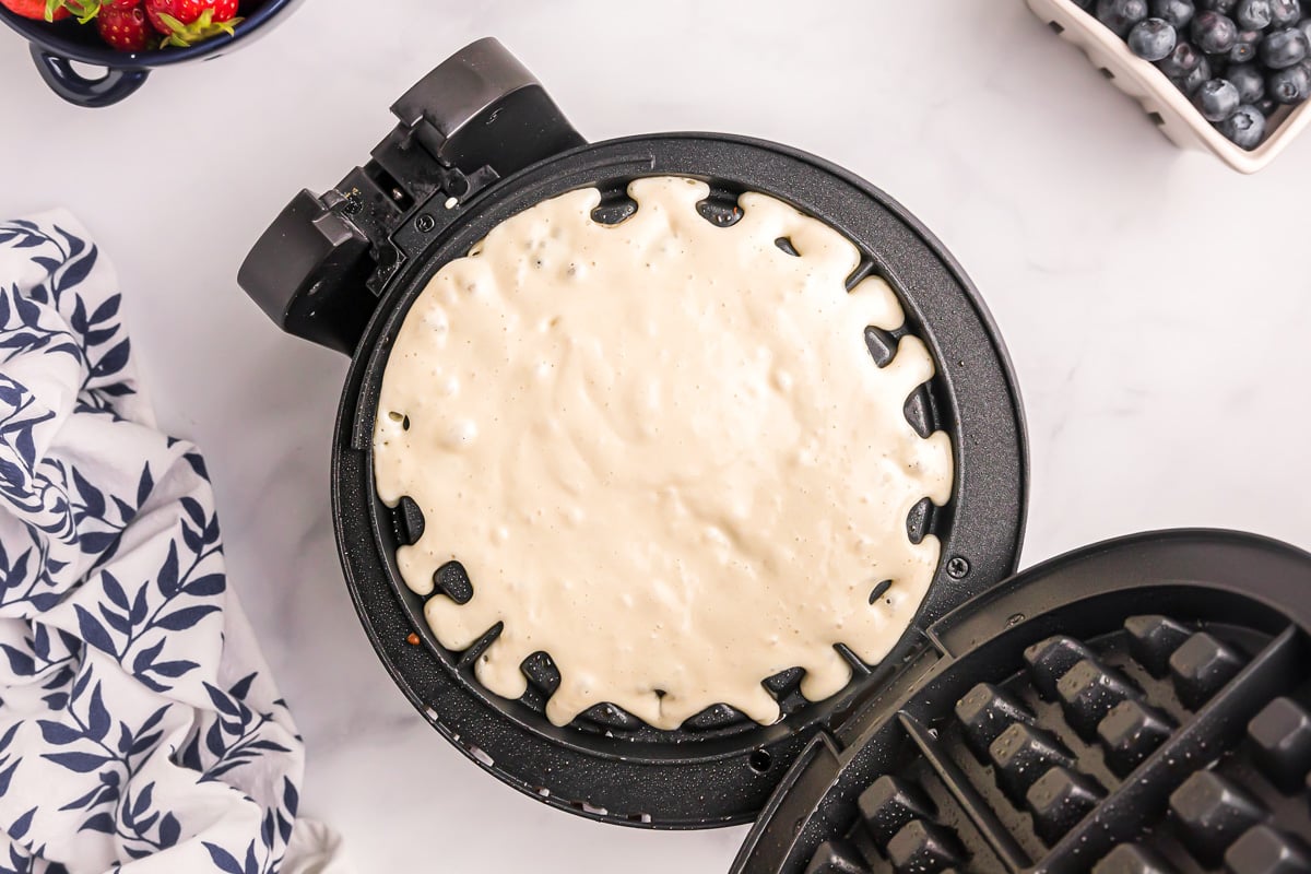 Bisquick waffle recipe cooking in a waffle iron.