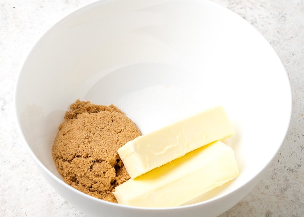 Brown sugar, sugar, and butter in a white bowl.