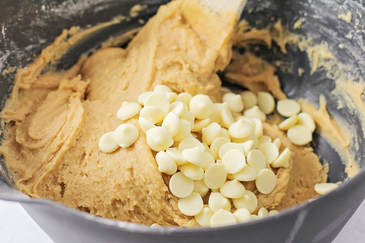Ingredients for blondie recipe being mixed in a bowl with a wooden spoon.