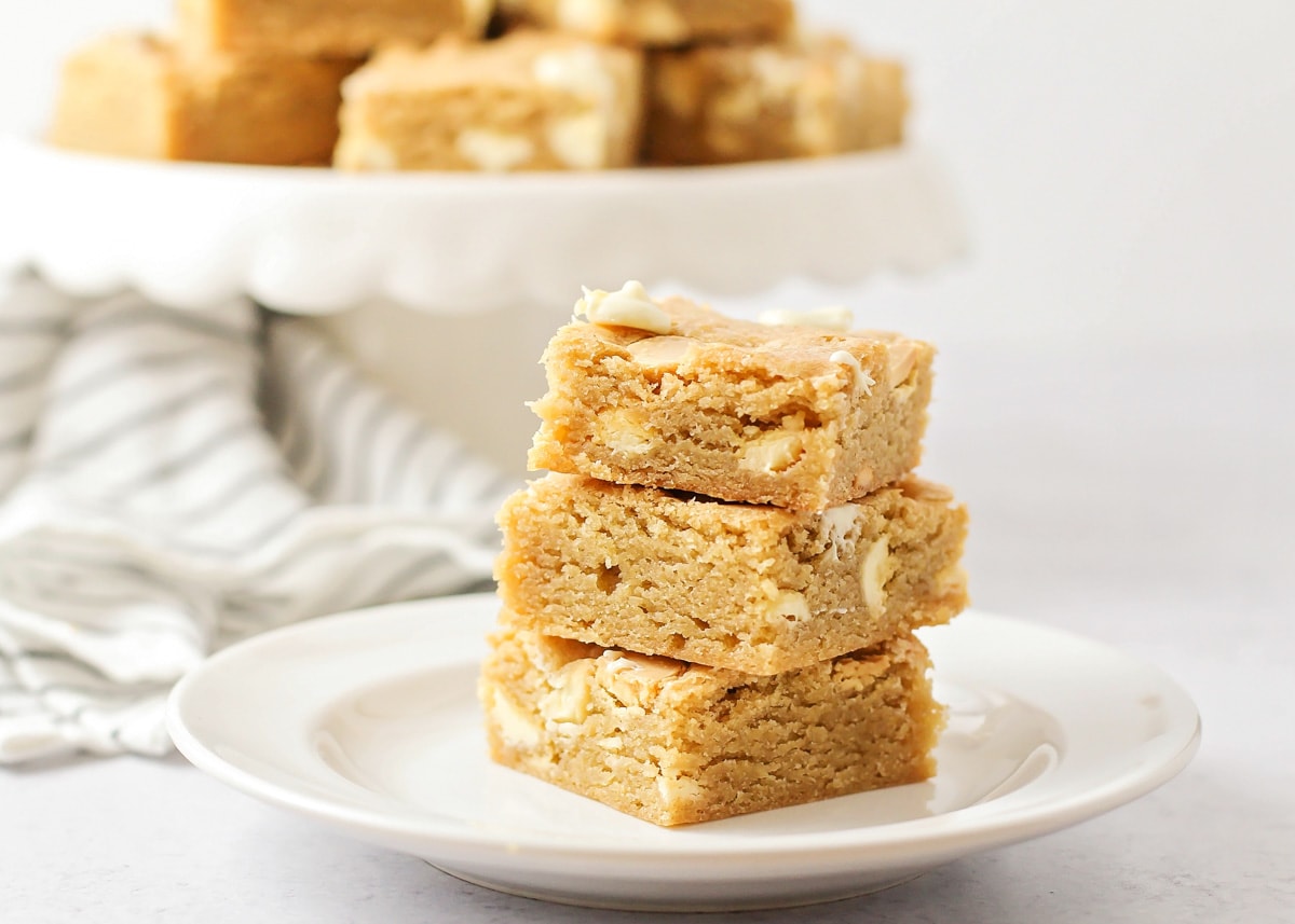 Blondies stacked on a white plate.