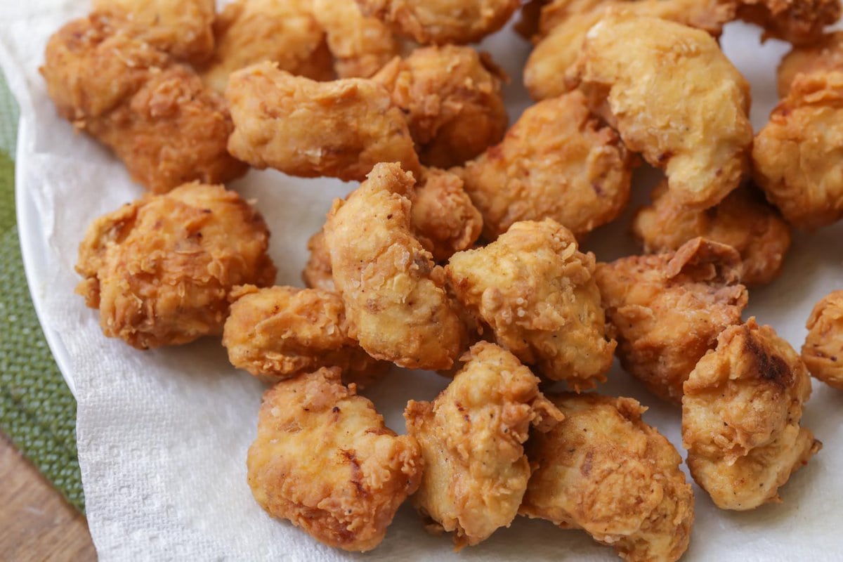 Fried boneless buffalo wings on paper towels.