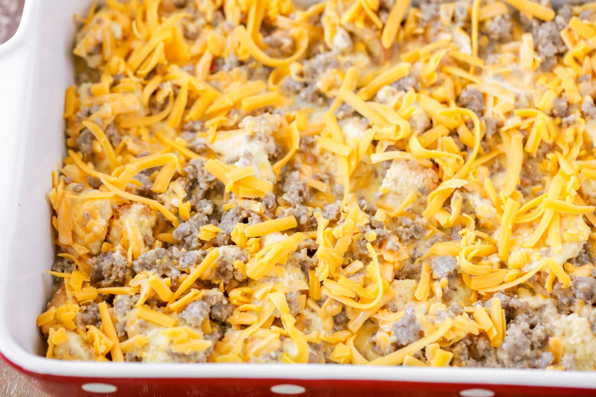 Savory Christmas breakfast casserole topped with cheese, ready to bake.