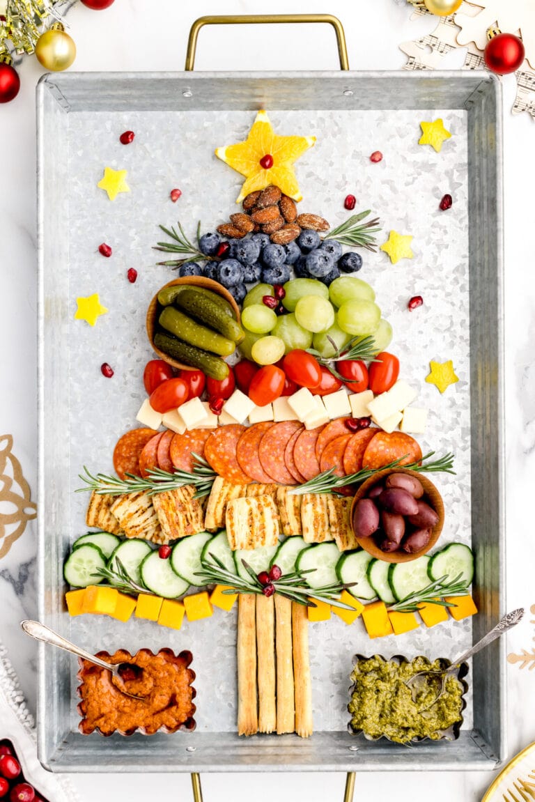Christmas tree charcuterie board with rosemary garnish.