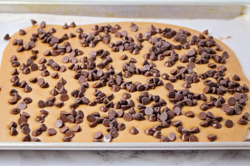 Chocolate chips spread out on hot toffee.