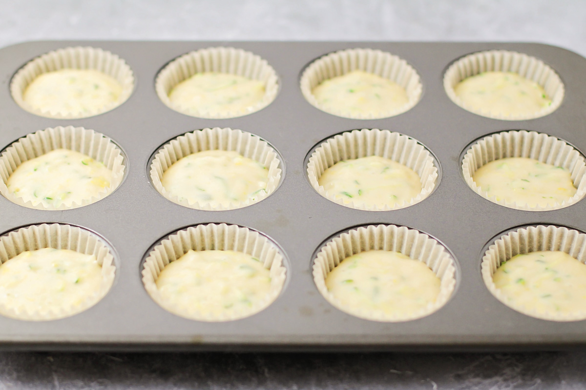 Muffin liners filled with lemon zucchini muffins.