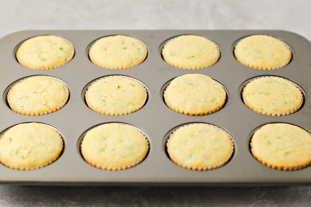 Fresh-baked lemon zucchini muffins in a tin.