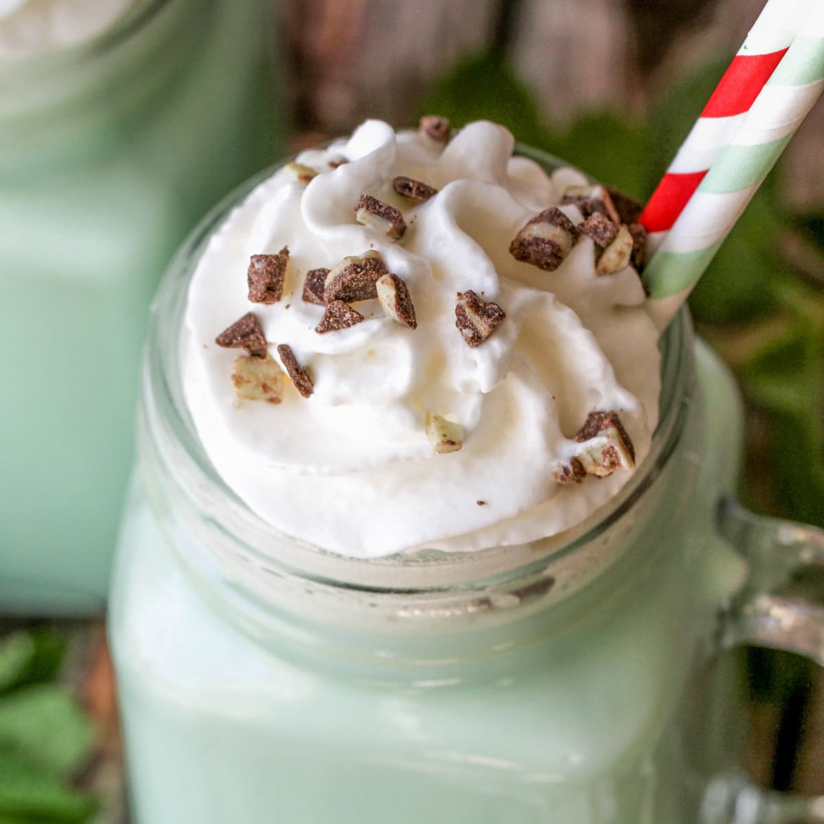 Whipped cream and Andes mints pieces on top of mint hot chocolate.