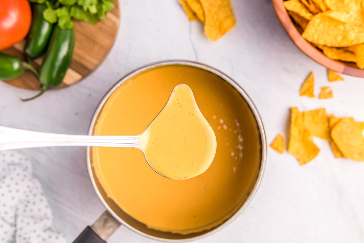 Ladling nacho cheese sauce for serving.