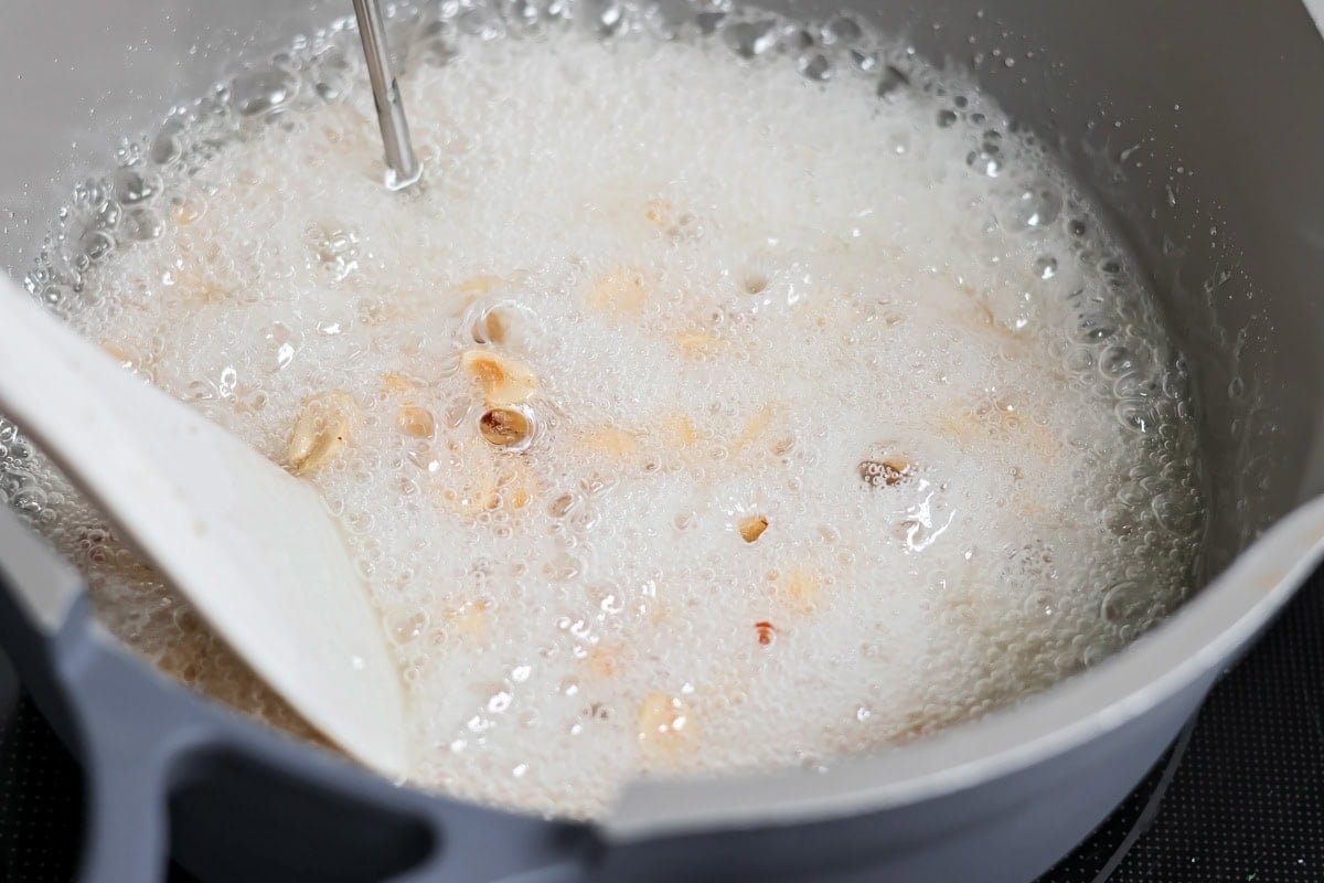 Boiling peanut brittle mixture in pot.