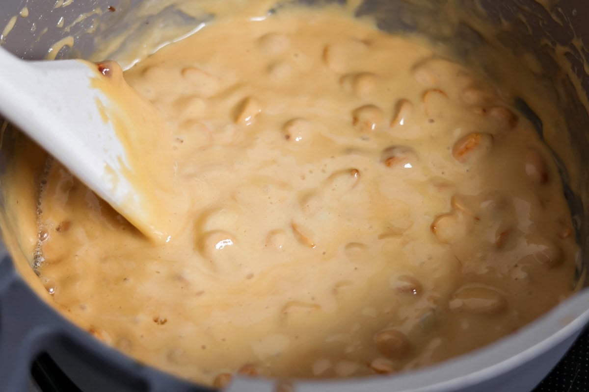 Adding baking soda to peanut brittle mixture.