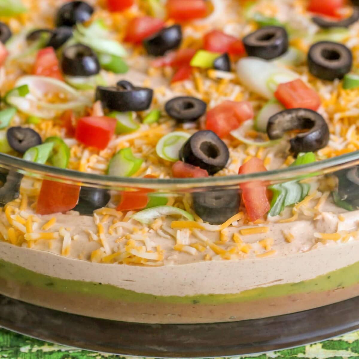 7 Layer Bean Dip served in a glass dish.