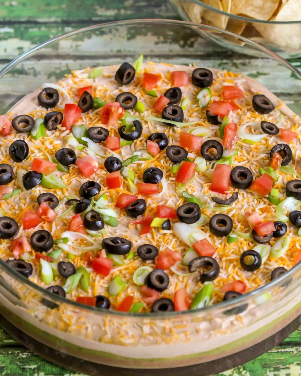 Close up of 7 Layered Bean Dip served in a glass bowl.