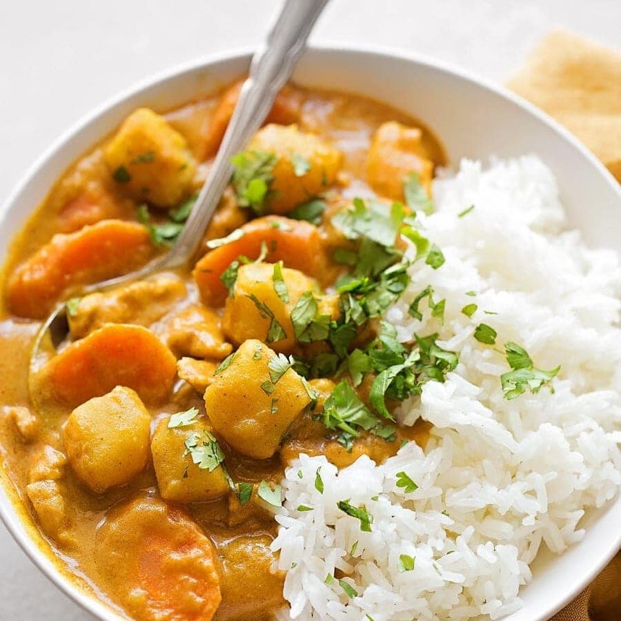 Coconut chicken curry recipe in white bowl.