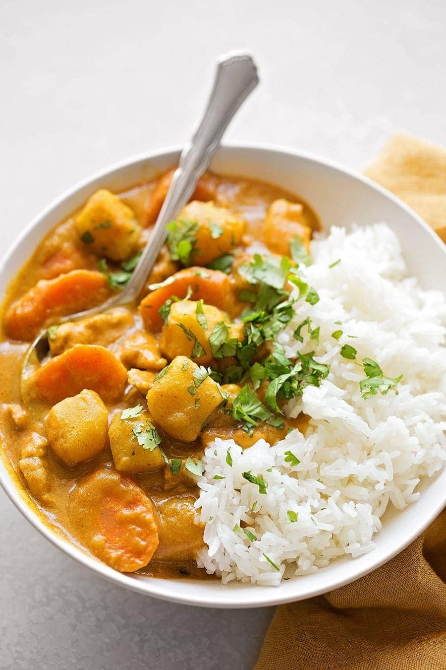 Coconut Curry Chicken in a white bowl served over rice.