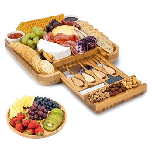 Charcuterie board with a variety of crackers, cheeses, meats, nuts and fruits served on it.