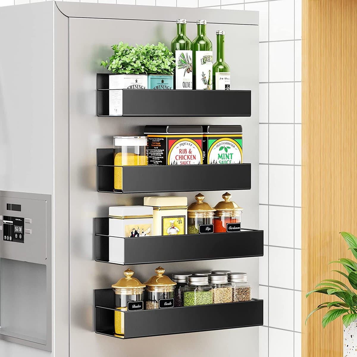 Kitchen organization ideas - Four black metal magnetic racks on the side of a fridge holding several spices and cooking essentials.