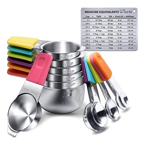 A set of stainless steel measuring cups and measuring spoons with colored handles and a stainless steel magnet with measure equivalent written on it.