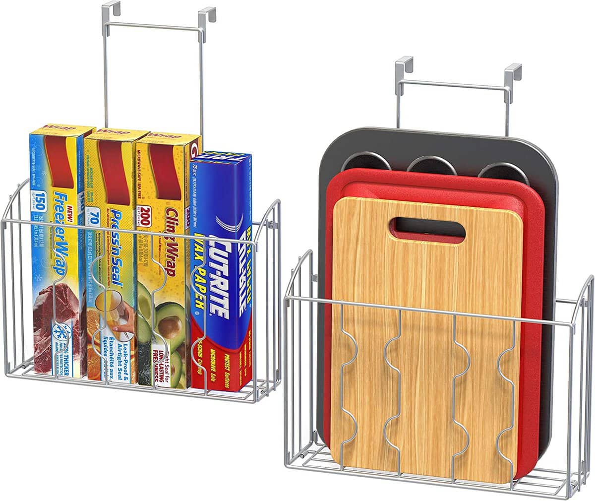 Kitchen organization ideas - Two metal organizers with hooks that hang over the cabinet doors, holding saran wrap boxes and cutting boards.