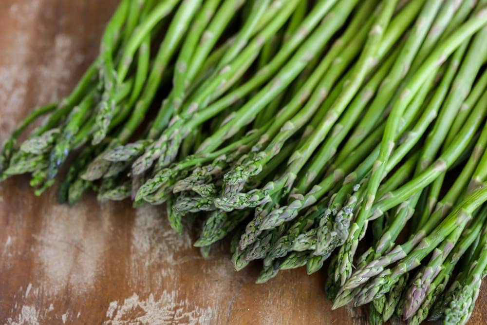 Raw asparagus on a cutting board.