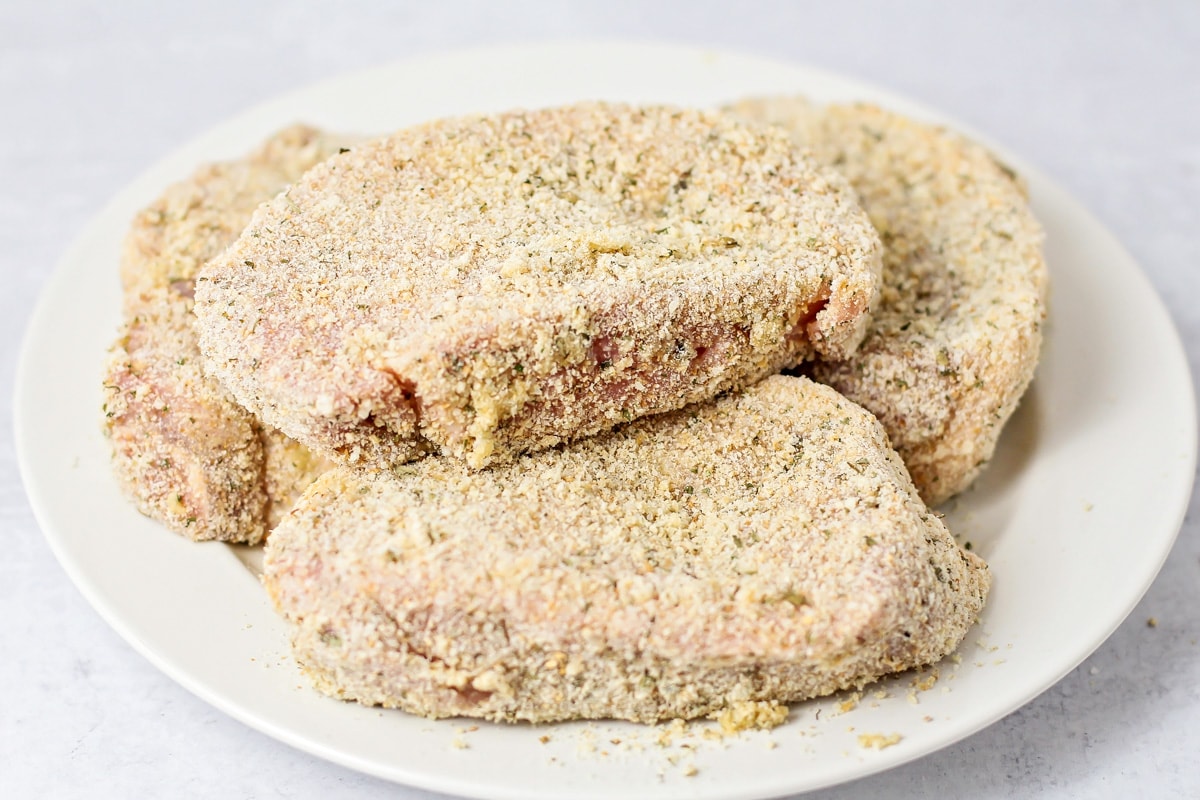 Breaded pork chops ready to be pan fried.
