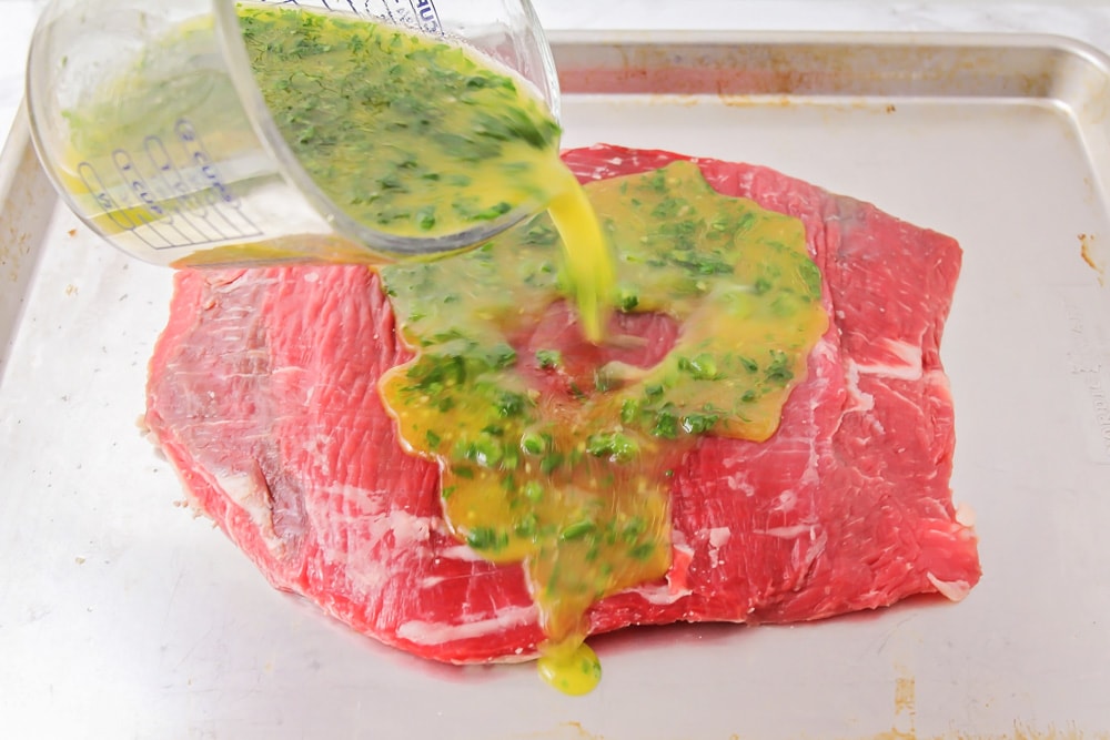 Marinade being poured over meat.