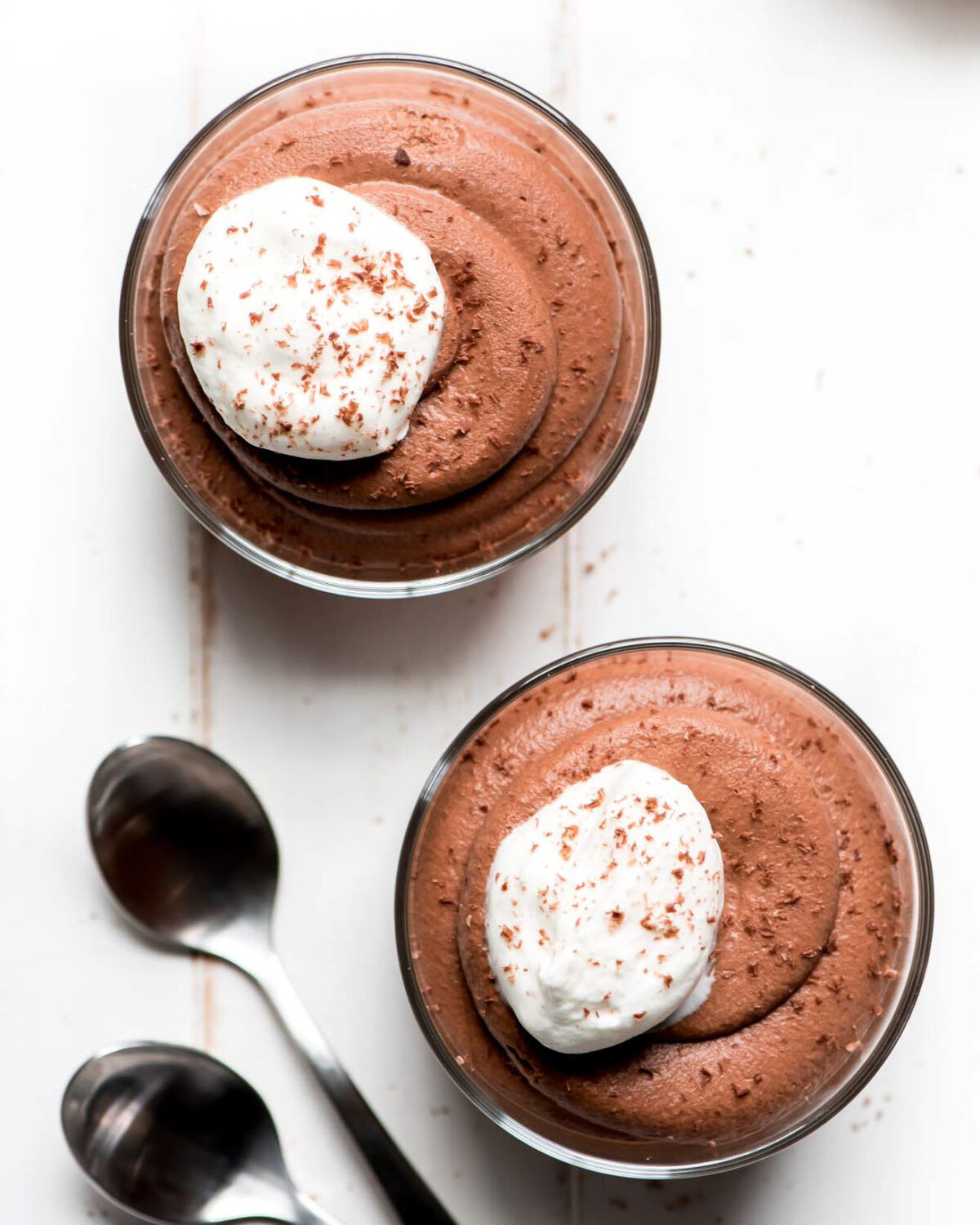 Easy chocolate mousse recipe shown in 2 glass cups topped with whipped cream.