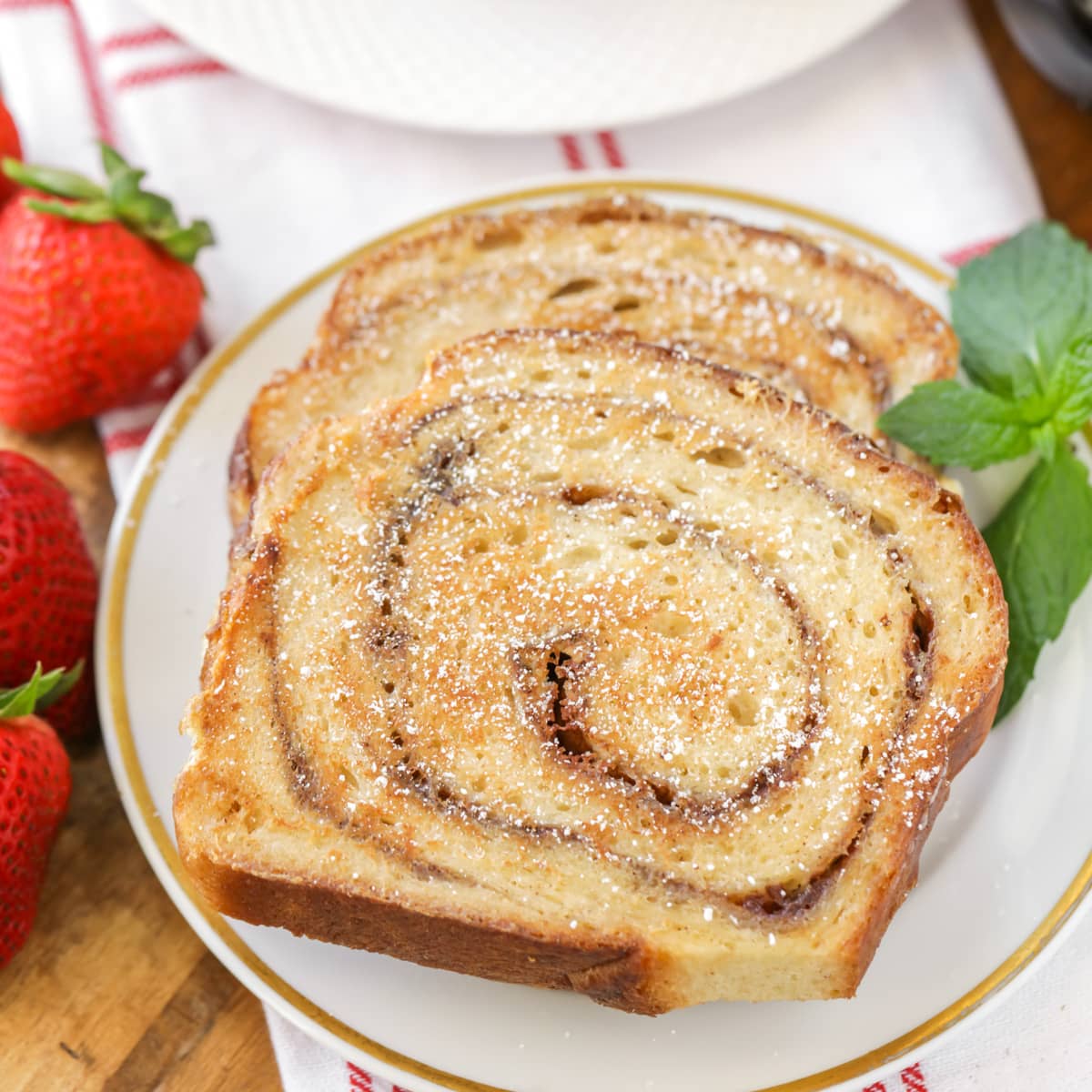 Cooked cinnamon bread french toast slices sprinkled with powder sugar.