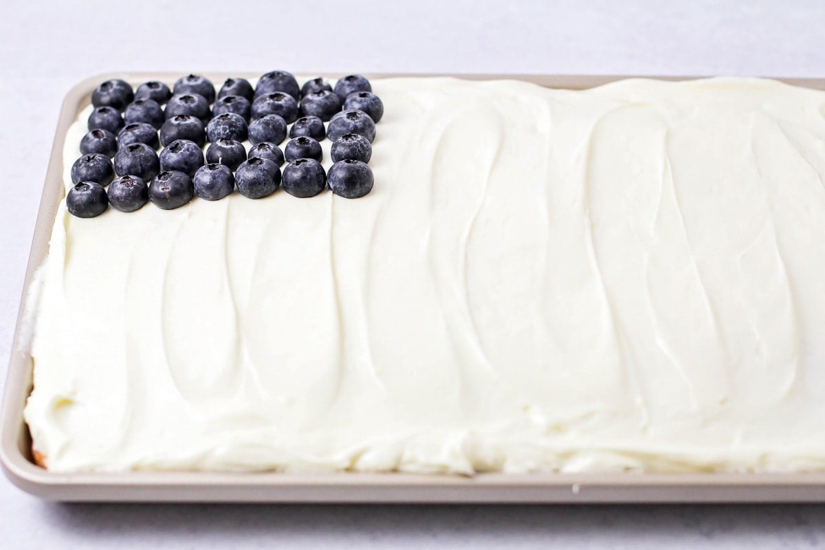 Decorating American Flag Cake with blueberries as stars.