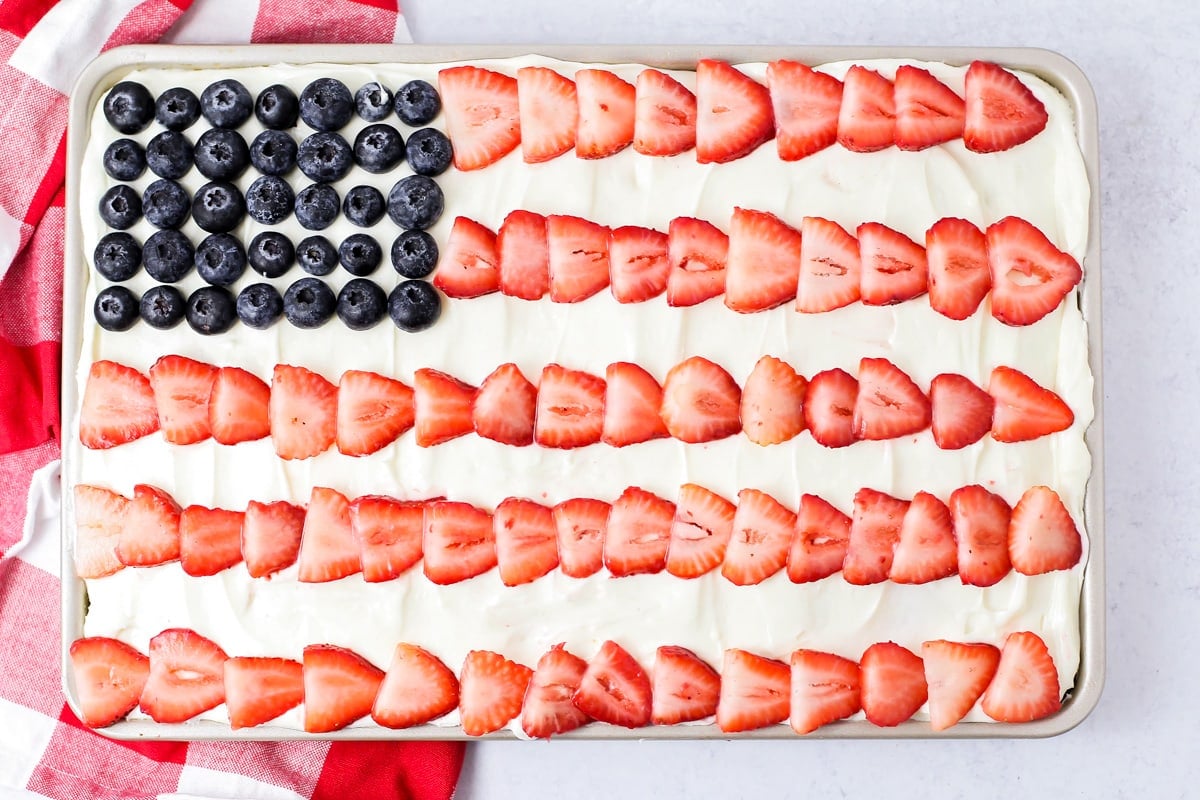Close up of American Flag Cake decorated with strawberries and blueberries.