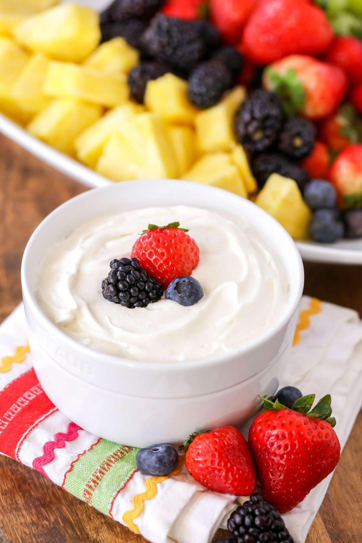 A bowl of fruit dip topped with fresh berries.