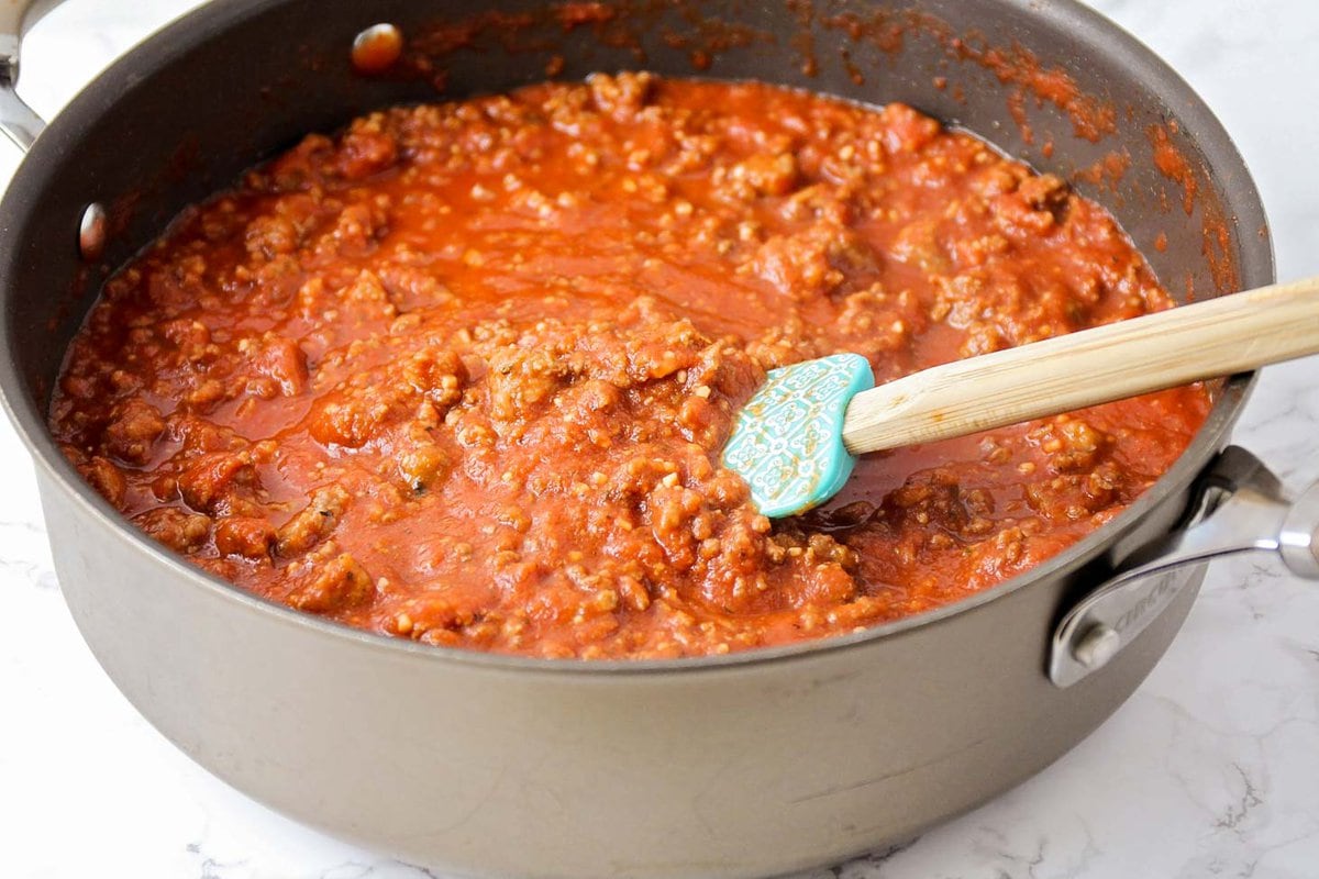 Meat sauce cooking in a pan for homemade lasagna layers.