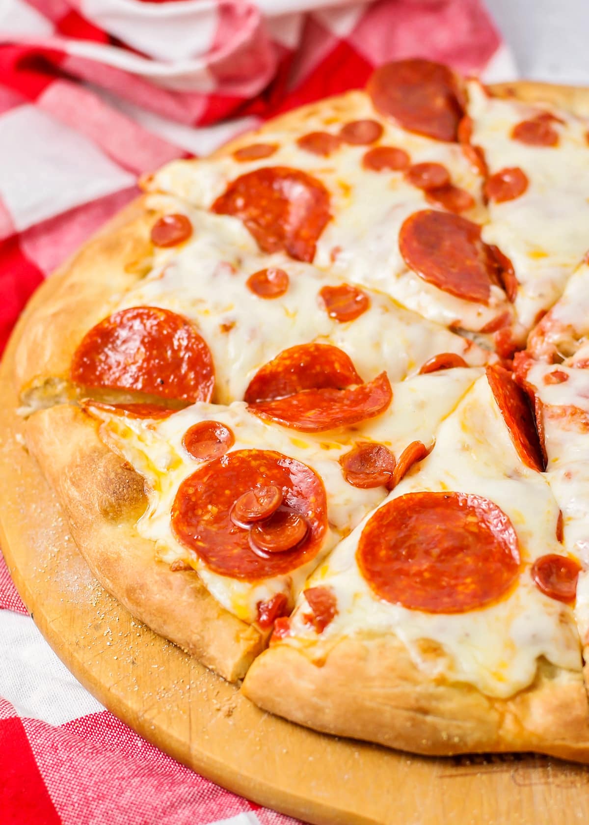 A close up of a baked and sliced homemade pepperoni pizza.