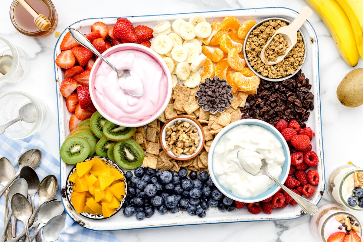 A yogurt parfait board filled with fruit and other toppings.