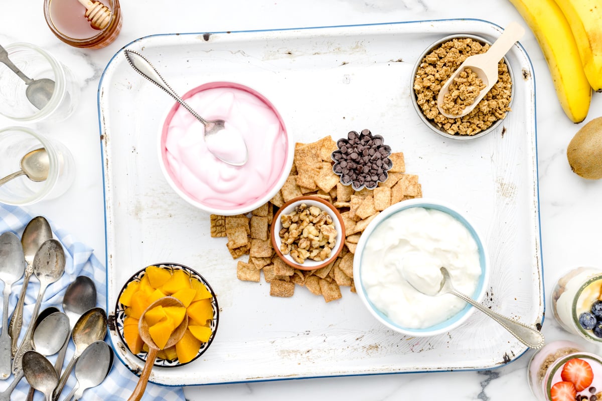 Filling the yogurt parfait board with a variety of ingredients.